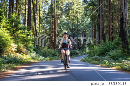 Adventurous Woman Bike Riding on a Trail in Forest Adventurous Woman Bike Riding on a Trail in Forest 83589113