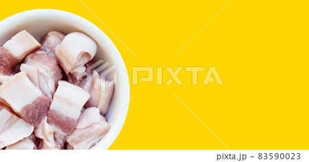 Streaky pork in white bowl on yellow background. Streaky pork in white bowl on yellow background. 83590023