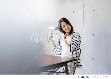 ドライヤーで髪を乾かす若い女性 83590272