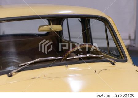 Old beige car. Braided steering wheel through the windshield. 83590400