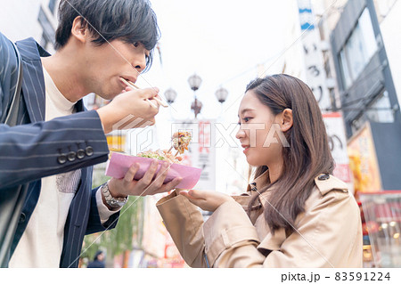 大阪を観光するカップル　道頓堀　たこ焼きを食べる 83591224
