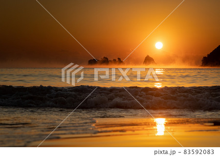 太平洋日向灘に昇る日出で黄昏色に染まった日南海岸の贄波浜と鳥帽子島に松島と黒島と間に広がる毛嵐 83592083
