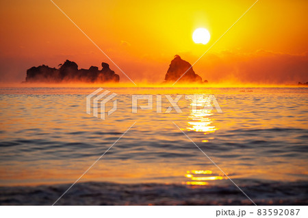 太平洋日向灘に昇る日出で黄昏色に染まった日南海岸の贄波浜と鳥帽子島に松島と黒島と間に広がる毛嵐 83592087