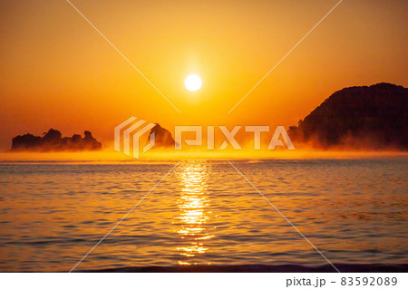 太平洋日向灘に昇る日出で黄昏色に染まった日南海岸の贄波浜と鳥帽子島に松島と黒島と間に広がる毛嵐 83592089
