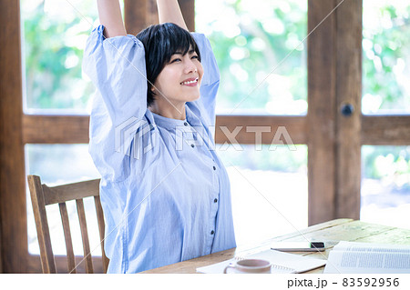 ストレッチで勉強疲れをリフレッシュする若い女性 83592956