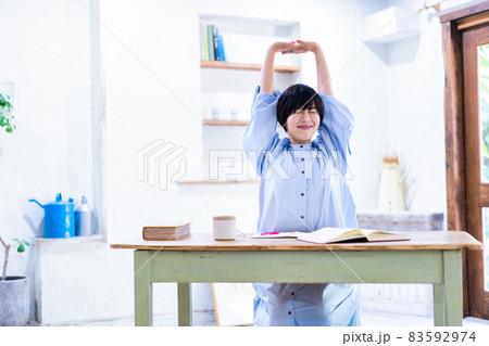 ストレッチで勉強疲れをリフレッシュする若い女性 83592974
