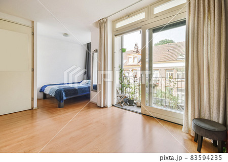 Bedroom with a single bed and a door leading to the balcony 83594235