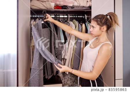 Wardrobe in bedroom and woman chooses clothes. Wardrobe in bedroom and woman chooses clothes. 83595863