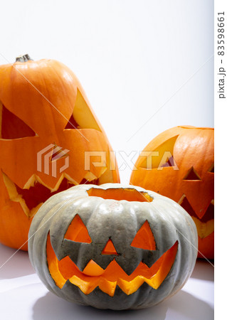 Composition of three halloween carved pumpkins with copy space on white background Composition of three halloween carved pumpkins with copy space on white background 83598661