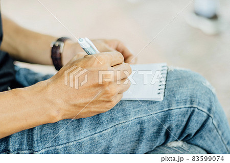 小さなノートにメモを取る 83599074
