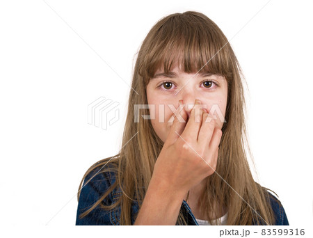 Little girl in checked brown shirt pinching her nose because of bad smell. She is unhappy with stench and looking at camera. Little girl in checked brown shirt pinching her nose because of bad smell. She is unhappy with stench and looking at camera. 83599316