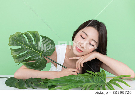 summer beauty concept, beautiful Korean Asian woman holding green leaves 83599726