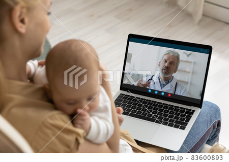 Mother holding baby, using laptop, making video call to pediatrician 83600893