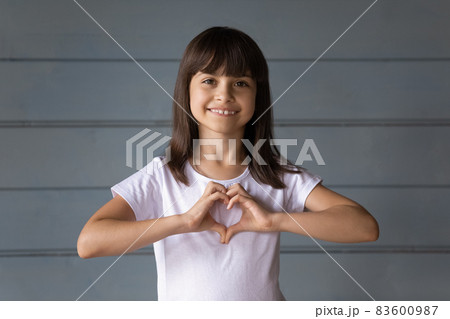 Happy joyful 7s girl making hand heart shape Happy joyful 7s girl making hand heart shape 83600987