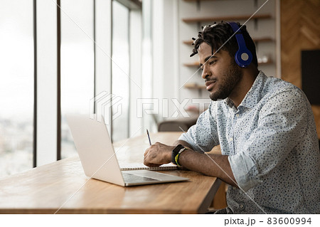 Focused young african american man studying on online courses. 83600994
