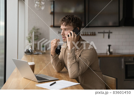 Concentrated young male manager multitasking in office. 83601450