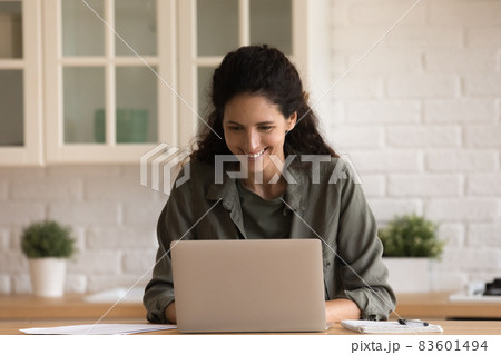 Beautiful young Hispanic woman freelancer working on laptop at home Beautiful young Hispanic woman freelancer working on laptop at home 83601494