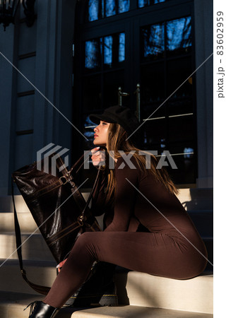 Fashionable young brunette woman with long legs wearing Solid Long Sleeve Bodycon One Piece Jumpsuits posing with a leather brown travel bag 83602959