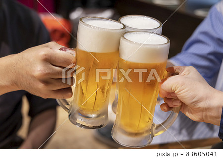 飲食店でジョッキの生ビールを乾杯する人たち 83605041
