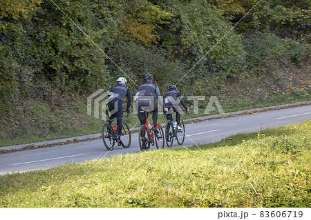 Group athletes cyclists riding a bike uphill along a road 83606719