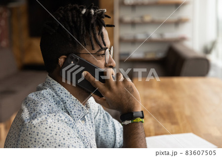 Joyful young african ethnicity businessman holding phone call conversation. 83607505