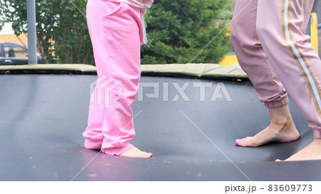young woman and a young girl are jumping on a ram, close-up. Legs float in the air after jumping on young woman and a young girl are jumping on a ram, close-up. Legs float in the air after jumping on 83609773