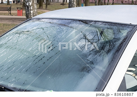 Glass of gray car with hoarfrost closeup 83610807