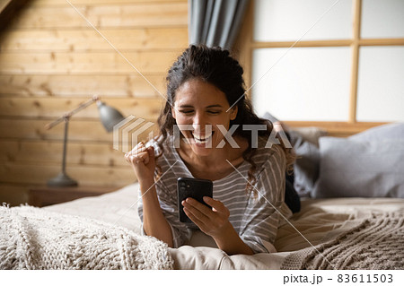 Cheerful excited woman holding smartphone, making winner yes hand 83611503