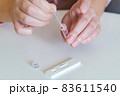The woman takes a blood sample with a pipette from his finger 83611540