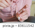 The woman takes a blood sample with a pipette from his finger 83611542
