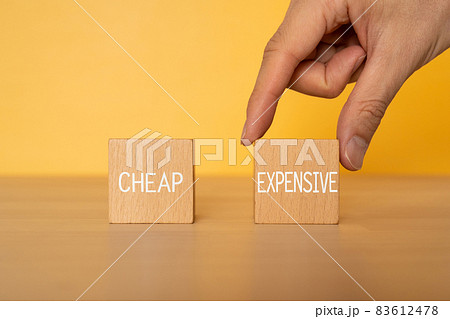 「CHEAP」「EXPENSIVE」と書かれた積み木と手 83612478