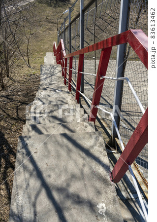 Narrow pedestrian staircase with red railings. 83613462