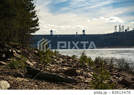 Rocky river bank against the background of the hydroelectric power station. 83613476