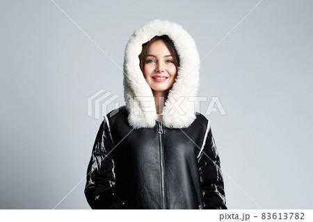 Happy young woman wearing a fur Hood 83613782