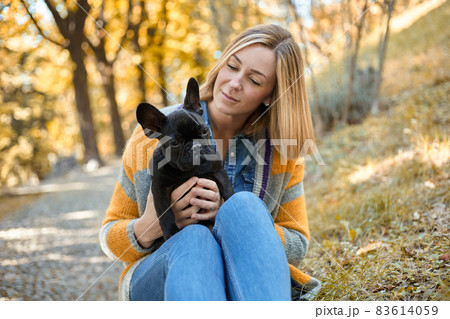 Closeup on happy young woman with dog outdoors in autumn 83614059
