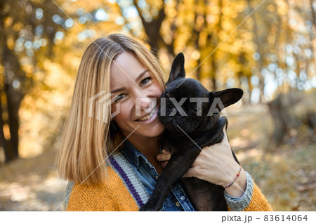 Closeup on happy young woman with dog outdoors in autumn 83614064
