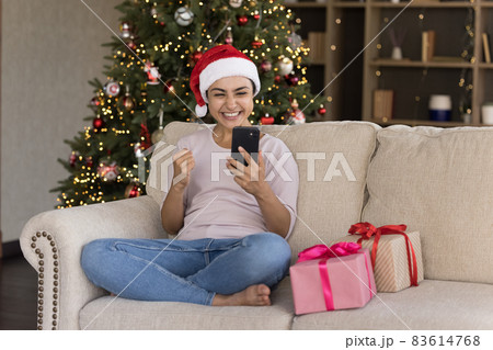 Joyful young Indian woman celebrating internet success. 83614768