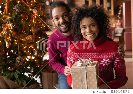 Portrait of happy biracial couple on New Year Eve Portrait of happy biracial couple on New Year Eve 83614875