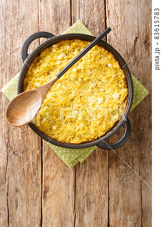 Patatnik or patetnik is a traditional Bulgarian potato based dish prepared with grated potatoes bryndza onions, as well as spearmint close-up. Vertical top view 83615783