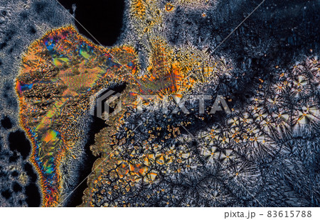 Extreme macro photograph of Vitamin C crystals forming abstract modern art patterns, when illuminated with polarized light, under a microscope objective with 10x magnification Extreme macro photograph of Vitamin C crystals forming abstract modern art patterns, when illuminated with polarized light, under a microscope objective with 10x magnification 83615788