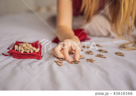 Woman making Christmas advent calendar. Pouches on a rope Woman making Christmas advent calendar. Pouches on a rope 83616566
