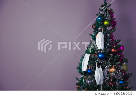 Christmas tree with decoration and face masks as a symbol of coronavirus 83616619