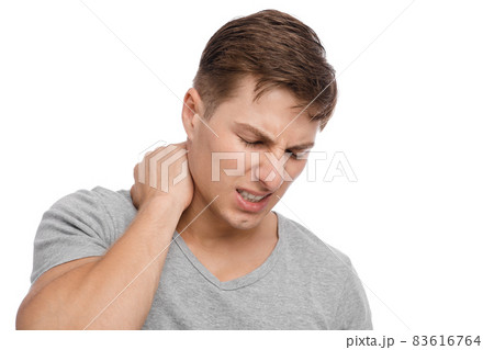 Unhappy millennial caucasian attractive guy presses hands to sore spot and suffers from neck pain Unhappy millennial caucasian attractive guy presses hands to sore spot and suffers from neck pain 83616764