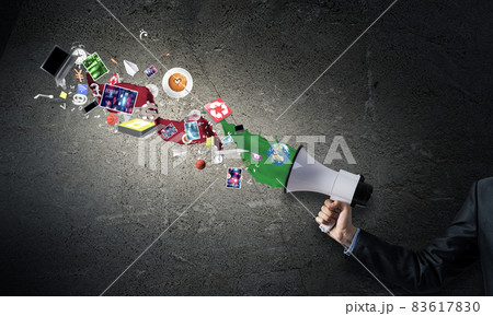 Businessman hand holding megaphone on wall Businessman hand holding megaphone on wall 83617830