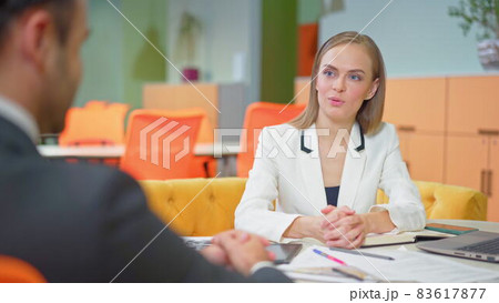 Employee in a suit nervous during a job interview. Close-up of two business people sitting in the workplace with documents. Successful interview with a supervisor and employee Employee in a suit nervous during a job interview. Close-up of two business people sitting in the workplace with documents. Successful interview with a supervisor and employee 83617877
