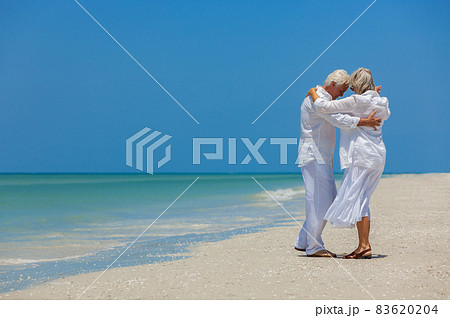 Happy Senior Couple Dancing on a Tropical Beach Happy Senior Couple Dancing on a Tropical Beach 83620204