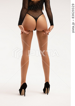 Seductive woman wearing black bodysuit and high heels 83620329
