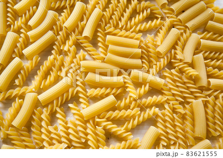 Top view image of Macaroni pasta. Raw pasta as background, close up. Italian wheat pasta on a white table, background texture, healthy food. High-quality photo Top view image of Macaroni pasta. Raw pasta as background, close up. Italian wheat pasta on a white table, background texture, healthy food. High-quality photo 83621555