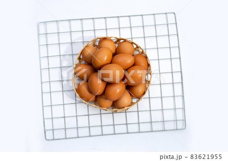 Chicken eggs in bamboo basket on white. Chicken eggs in bamboo basket on white. 83621955