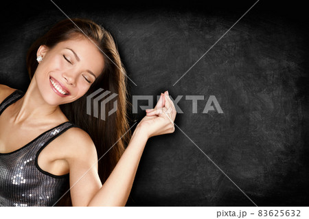 Music woman dancing having fun snapping fingers to song partying in nightclub party with blackboard texture for text copy space advertising. Club young people lifestyle. Music woman dancing having fun snapping fingers to song partying in nightclub party with blackboard texture for text copy space advertising. Club young people lifestyle. 83625632